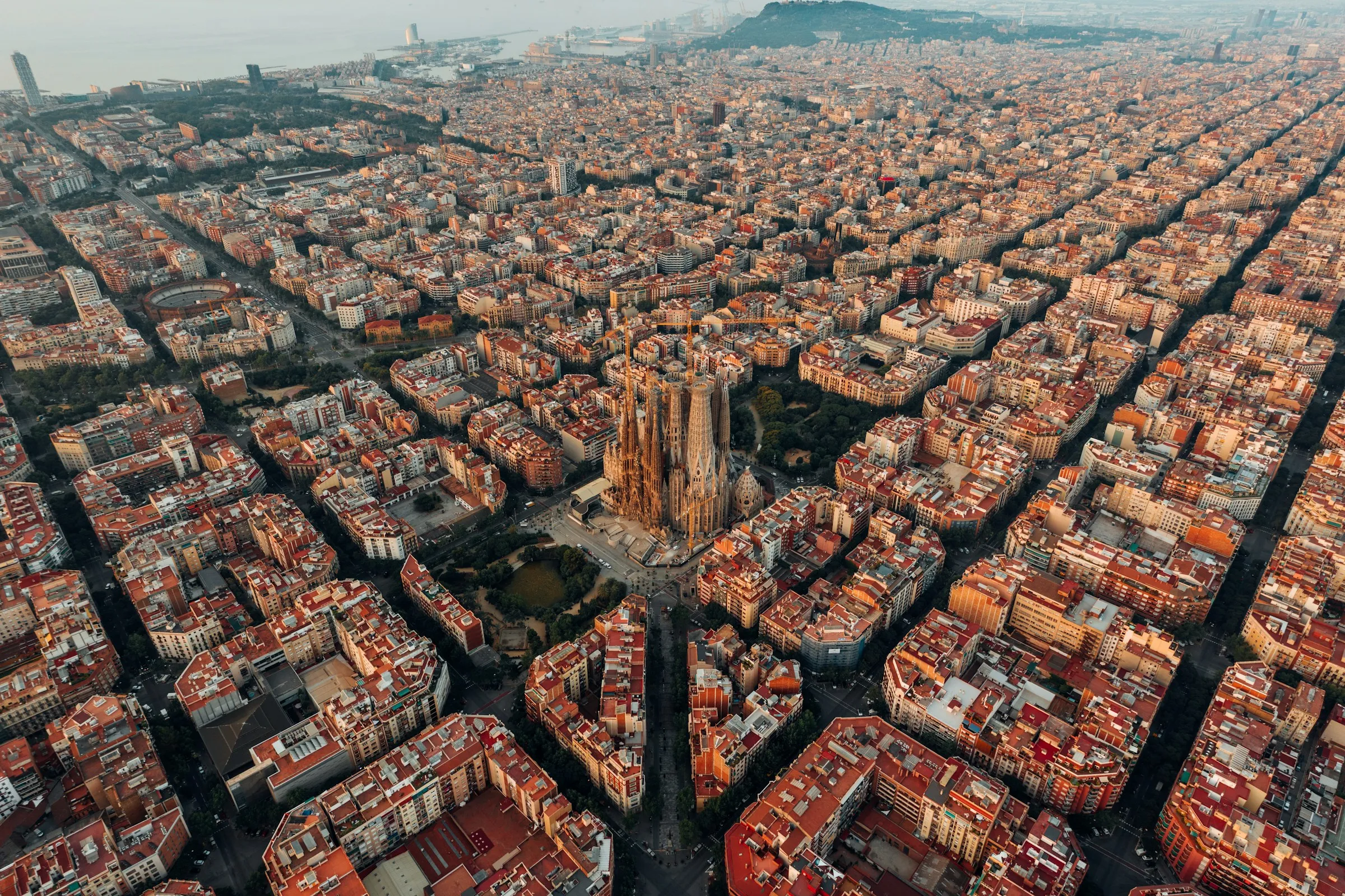 Vista aérea de Barcelona mostrando barrios en transformación urbana con edificios residenciales y grúas de construcción