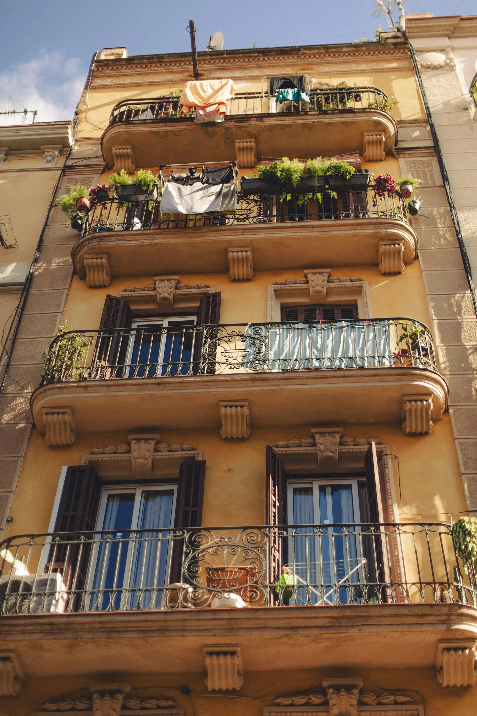 Fachada de edificio residencial en Barcelona con balcones de hierro forjado y arquitectura clásica del Eixample